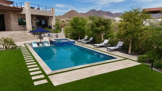 Luxury rectangular pool with spa, tanning ledge, and desert mountain backdrop