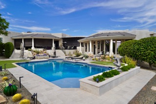 Elegant pool with lounge chairs, spa, and manicured landscaping