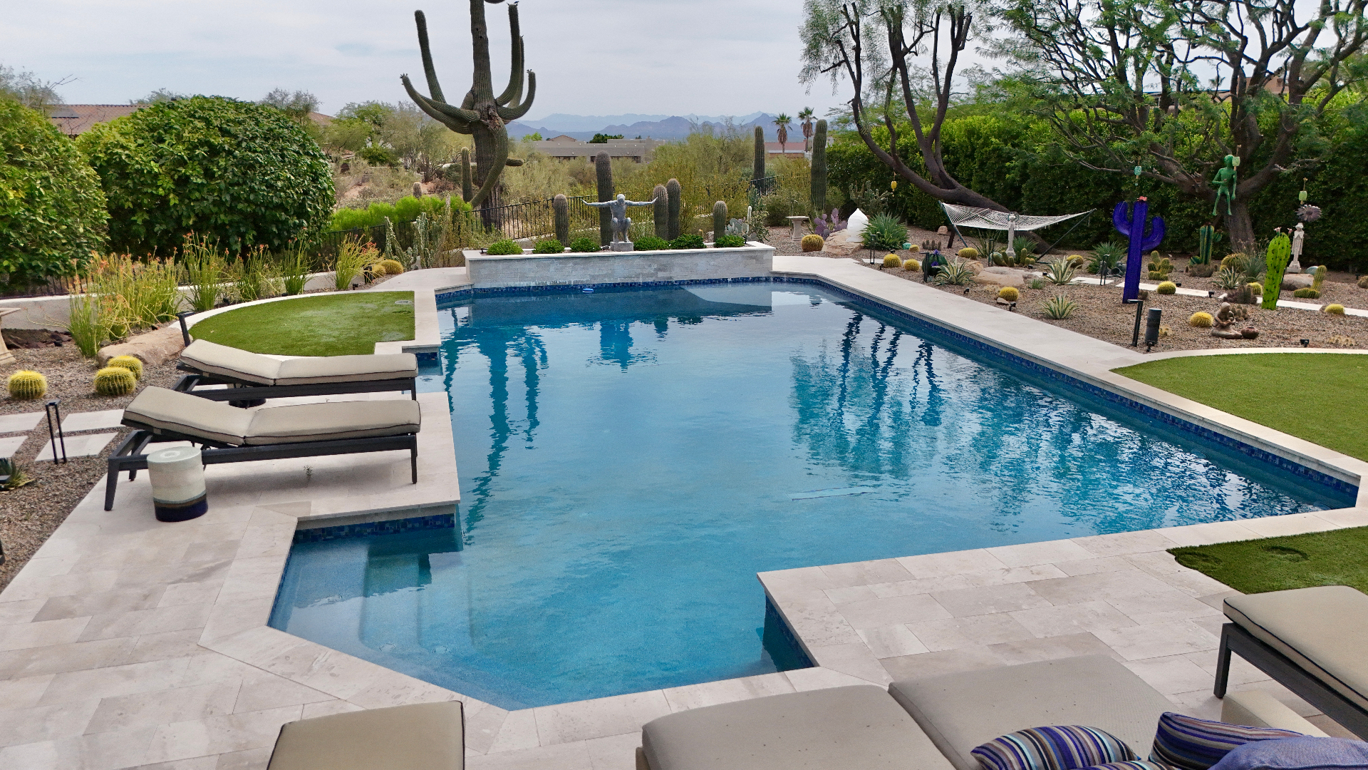 Expansive rectangular pool with cactus garden and mountain backdrop