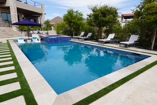 Rectangular pool with mosaic tile, spa, and turf inlay walkway