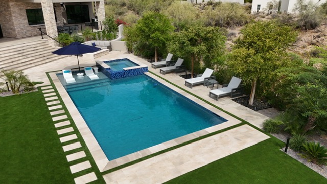 Aerial view of rectangular pool with spa and travertine deck